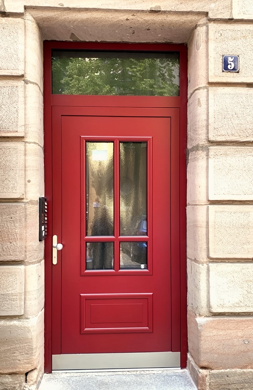 Erneuerte Haustür an einem Mehrfamilienhaus mit Oberlicht