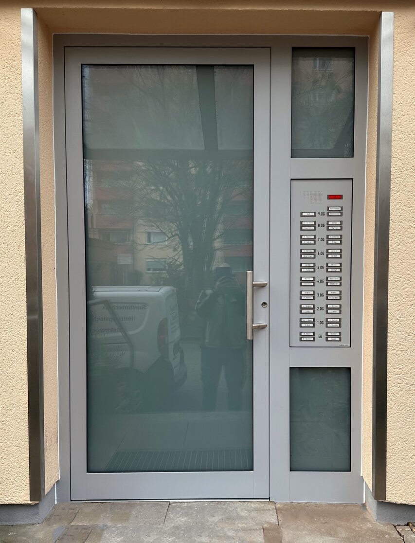 Erneuerte Haustür an einem Hochhaus mit Seitenteil und Klingelanlage
