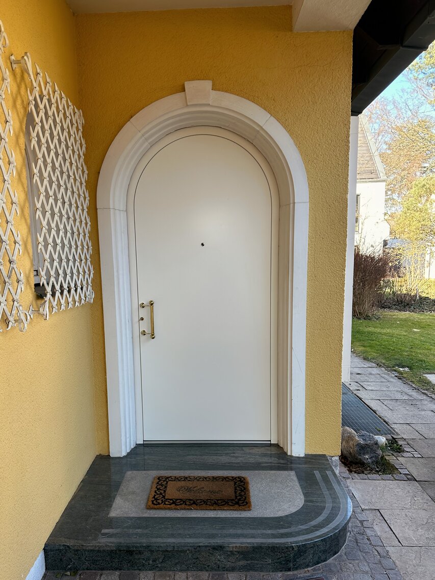 Erneuerte Rundbogen-Haustür an einem Einfamilienhaus